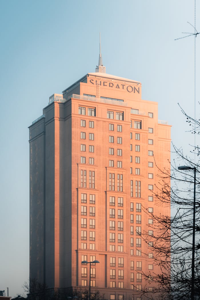 Elegant Sheraton hotel bathed in soft sunlight against a clear blue sky.