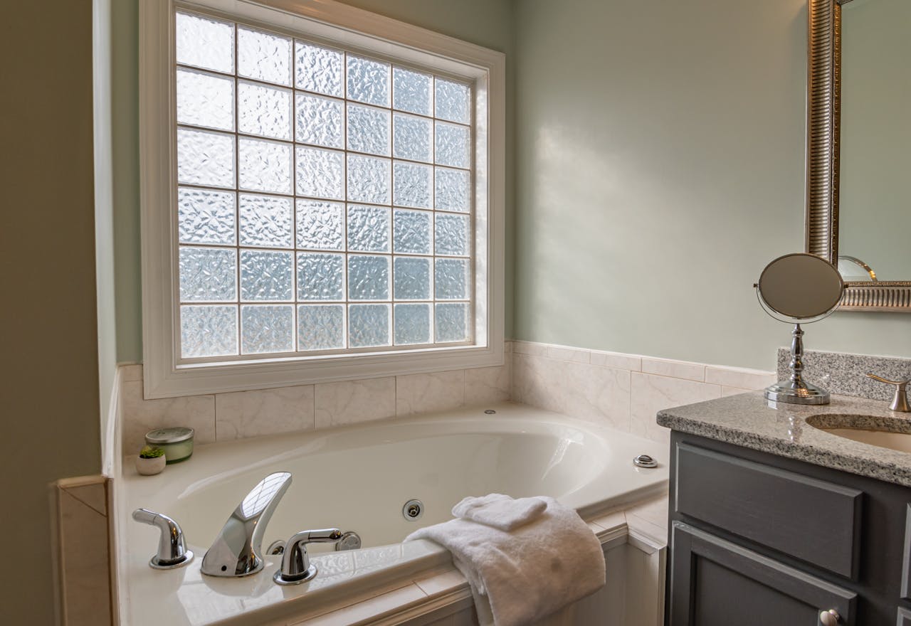 services-03 Stylish modern bathroom featuring a luxury bathtub, sleek sink, and large window. Perfect for relaxation.